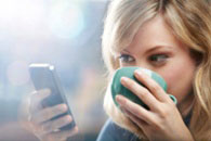 Women looking at iPhone while drinking coffee
